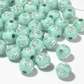 Detailed macro view of 8mm mint green acrylic beads featuring silver cross pattern designs - 1800 Pieces/Pack / Silver Line Lake Blue
