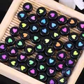 Vista dettagliata di perline acriliche nere da 7 mm con motivi a cuore colorati - 4mm x 7mm, 4000 Pezzi / Nero con motivo multicolore