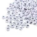 Macro detail of 4x7mm white acrylic flat round beads with black alphabet letters - Letter W / 100 Pieces/Pack / White Base Black Font