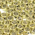 Primo piano di perline in acrilico dorato da 7mm con lettere cirilliche nere - 3800 Pezzi/Confezione / Base Oro con Testo Nero