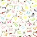 Macro view of 7mm white acrylic flat beads featuring colorful Russian Cyrillic letters - 3800 Pieces/Pack / White Base Colored Letter