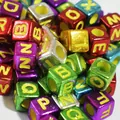 Detailed macro shot of 6mm metallic square acrylic alphabet beads for DIY jewelry making crafts - Plated Multicolor With Yellow Letters