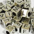 Close-up of 6mm silver acrylic cube beads with black engraved letters for DIY jewelry - Silver Base with Black Text