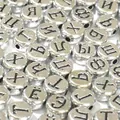 Primo piano di perle piatte in acrilico argento da 7 mm con lettere russe nere - 3800 Pezzi/Confezione / Base Argento con Testo Nero