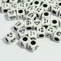 Close-up of 6mm white acrylic cubic beads with black smile face patterns for DIY crafts - 3000 Pieces/Pack / White Base Black Font