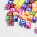 Macro shot of colorful 6mm acrylic square beads with engraved white smiley faces - 3000 Pieces/Pack / Colorful Base with White Letters