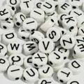 Close-up detail of 7mm white acrylic alphabet beads with black letters for DIY crafts - 4000 Pieces/Pack / White Base Black Font