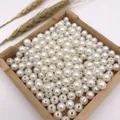 Detail view of round white ABS imitation pearl beads with straight holes. - 3mm / Off White