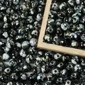 Close-up macro view of 8mm black acrylic beads with white splattered ceramic effect - 500g/8mm/1800 Pieces/Pack / Black