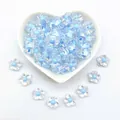 Close-up of 12mm transparent acrylic five-petal flower beads with blue centers for DIY crafts - 12mm / Five-Petal Plum Blossom Style / 1000 Pieces/Pack / Light Blue