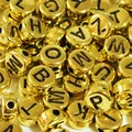 Macro close-up of golden acrylic flat round alphabet letter beads for DIY crafts - 4000 Pieces/Pack / Gold Base with Black Text