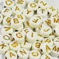 Close-up of 7mm white acrylic beads with golden alphabet letters for DIY jewelry making - 4000 Pieces/Pack / White with Gold Print