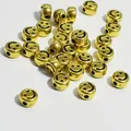 Close-up of golden acrylic round flat beads with black smiley face for DIY jewelry - 4000 Pieces/Pack / Gold Base With Black Lines