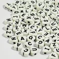 Close-up macro view of white heart shaped acrylic beads with black letter prints for DIY - 3800 Pieces/Pack / White Base Black Line