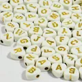 Macro view of 7mm white heart acrylic beads with gold embossed English alphabet letters - 3800 Pieces/Pack / White Base Gold Thread