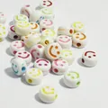 Primo piano di perline acriliche bianche da 10 mm con faccine colorate per gioielli fai-da-te - Base Bianca Lettera Colorata