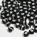 Macro view of 7mm black heart-shaped acrylic alphabet beads with white letters for DIY - 3800 Pieces/Pack / Black Base White Line