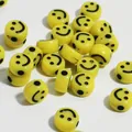Dettaglio ravvicinato di perle smiley in acrilico giallo per creazioni di gioielli fai da te - Giallo con ragnatela nera