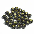 Dettaglio di perle acriliche nere da 10mm con lettere dorate per creazione gioielli. - 1600 Pezzi (6x10mm) / Base Nera Linee Dorate
