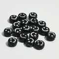 Dettaglio macro di perline tonde in acrilico nero da 10 mm con disegno a faccina - Base Nera Linea Bianca