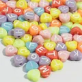 Close-up of multicolored 7mm heart-shaped acrylic alphabet beads for DIY crafts - 3800 Pieces/Pack / Colorful Base with White Letters