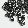 Macro view of 6mm black acrylic cube beads with white star, moon, and heart patterns. - 3000 Pieces/Pack / Black and White