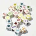 Close-up of 7mm white acrylic cube beads with colorful printed zodiac symbols - 7mm (1950 Pcs/Pack) / White Base Colored Letter
