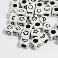 Detailed view of 6mm white acrylic square beads featuring black star and moon patterns - 3000 Pieces/Pack / White Base Black Font