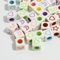 Close-up macro view of colorful 6mm acrylic cube beads with heart and star patterns - 3000 Pieces/Pack / White Base Colored Letter
