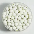 Macro view of 8mm white matte round acrylic spray-painted beads in a container - 1800 Pieces/Pack / White