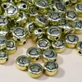 Macro detail of 7mm golden acrylic beads with engraved star and moon patterns - Gold Base with Black Text