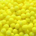 Macro detail of matte yellow acrylic beads with straight holes for DIY craft jewelry. - Yellow