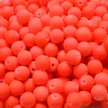 Macro detail of neon orange acrylic round beads with soft-touch rubber paint finish - Orange