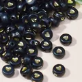 Dettaglio ravvicinato di perline acriliche nere da 7mm con cuori dorati per il fai da te. - 4mm x 7mm, 4000 Pezzi / Nero con testo oro