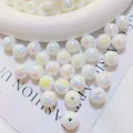 Close-up of iridescent AB plated white acrylic round loose beads for jewelry making. - White