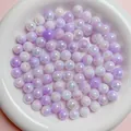 Macro view of 6-10mm iridescent lavender acrylic beads in a white bowl for DIY jewelry - Purple