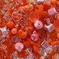 Close-up of mixed orange acrylic beads in heart, rose, and bow shapes for DIY crafts. - 400-500 Pieces Pack / Orange