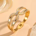 Detailweergave van een goudkleurige roestvrijstalen armband met pavé diamanten strikdesign. - Strik Strass Stijl (N312) / Goud