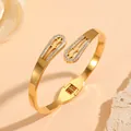 Close-up of gold stainless steel bangle with rhinestone encrusted cutouts - Flower Water Drop Rhinestone Style (N312) / Gold