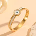 Detail view of gold evil eye bangle with rhinestones and white shell inlay for women - Evil Eye Style with Diamonds (H218) / Gold