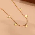 Macro-opname van gouden roestvrijstalen slangenketting met hangers van sterren en manen - Gouden ster en maan ketting