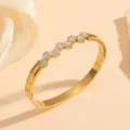 Detailed view of a gold titanium steel bangle with shimmering circular crystal accents. - Round Full Rhinestone Bangle (M712) / Gold