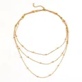 Detailopname van een drielaagse gouden kralenketting gemaakt van titanium staal. - Kralenketting Halsketting (B706) / Goud