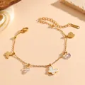 Gros plan sur un bracelet papillon en acier inoxydable doré avec insert en nacre - Bracelet Papillon Coquille Blanche Doré (C721)