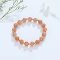 Elegante kristallen kralenarmband met perzikkleurige stenen en gouden tussen kralen - Zonnesteen Gouden Kraal Stijl