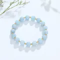 Elegante lichtblauwe kristallen kralenarmband met gouden spacers op witte achtergrond - Aquamarijn Gouden Kraal Stijl
