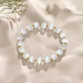 Elegant wit kattenoog kristallen kralenarmband met gouden accenten op zachte stof. - White Cat Eye Gold Style