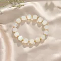 Elegant kralenarmband met witte kristallen en gouden accenten op zijden achtergrond - White Moonstone Gold Style