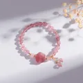 Detail van natuurlijke aardbeienkwarts armband met kattenpoot bedeltje en kwastjes - Aardbeienkwarts Kattenpoot Stijl