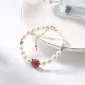 Elegant freshwater pearl bracelet with cinnabar owl and turquoise accents on white plate - Pearl Owl Cinnabar Style